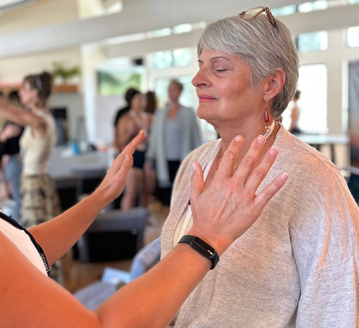 Facilitator guiding a client through energetic attunement with hands near the heart