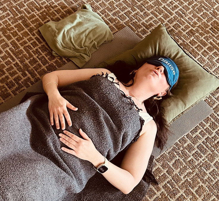 Student resting in a Pause breathwork session wearing a Pause eye mask